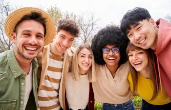 Large group of cheerful young friends taking selfie portrait. Happy people hugging each other.