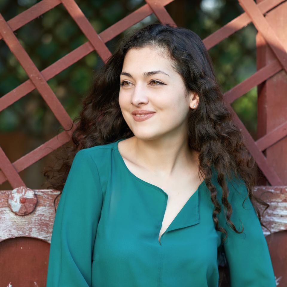 beautiful woman posing near red painted old wooden wall