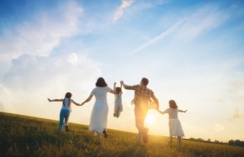 Happy family on summer walk! Mother, father and daughters walking in the Park and enjoying the beautiful nature.