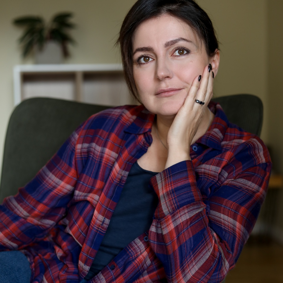 Attractive brunette woman relax in comfortable armchair in home room and thoughtfully look away. Adult female people enjoying quiet lifestyle indoor. Cozy resting place, leisure, interior.