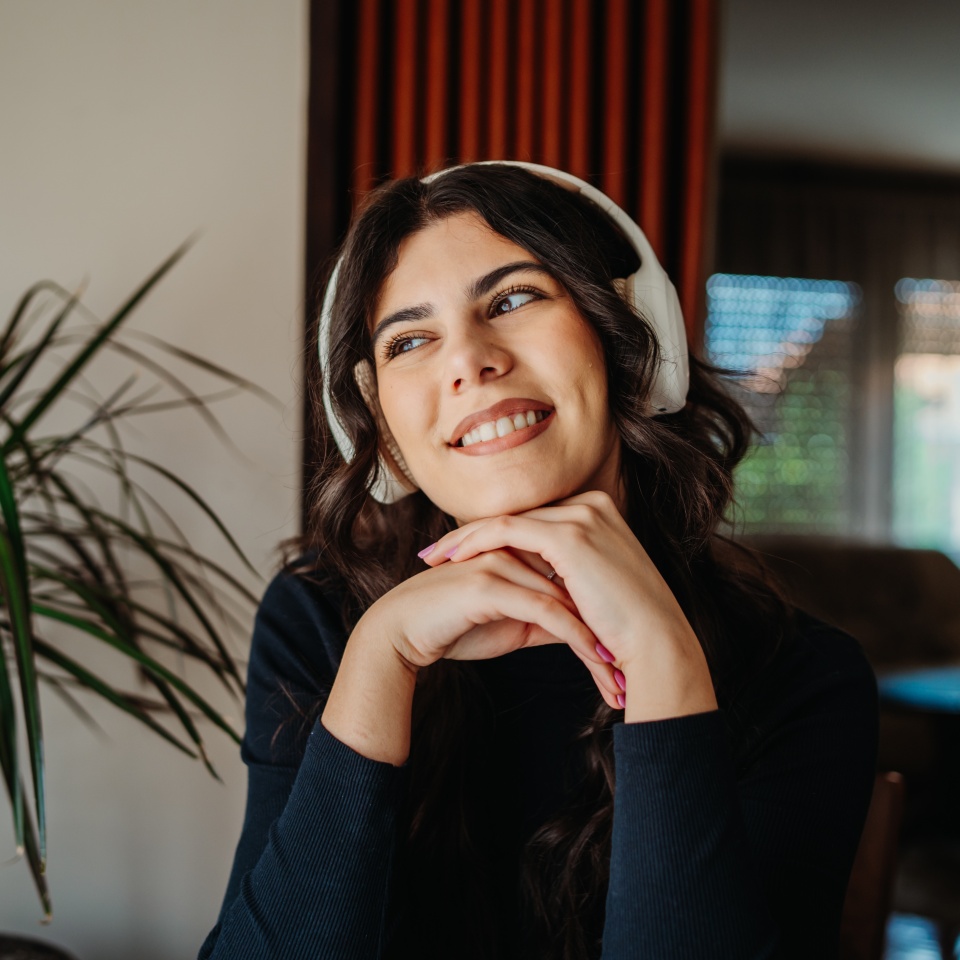 One young caucasian woman is listening to music on her wireless headphones in the morning before going to work