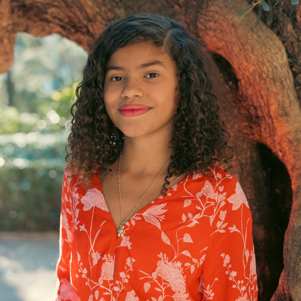 Young woman posing near a tree in a park