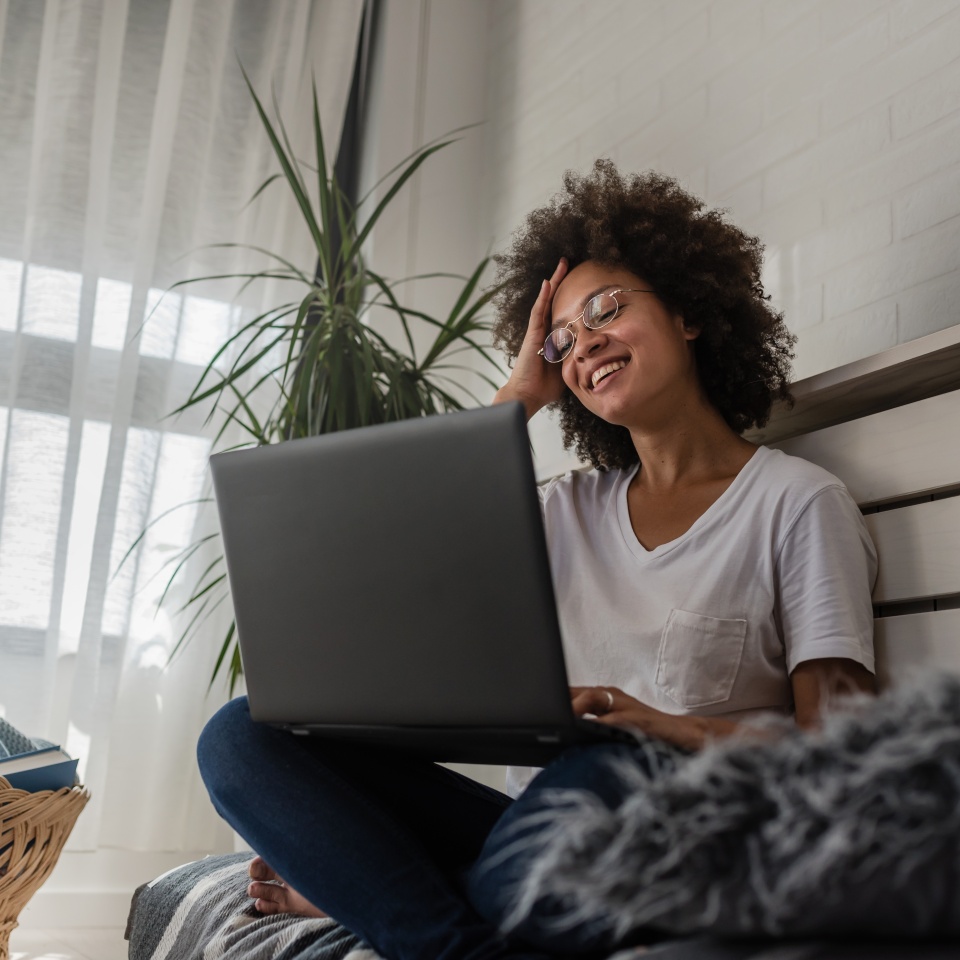 Beautiful African-American young Woman reading a book at home. Cozy corner. Education. Daydreaming and passion concept