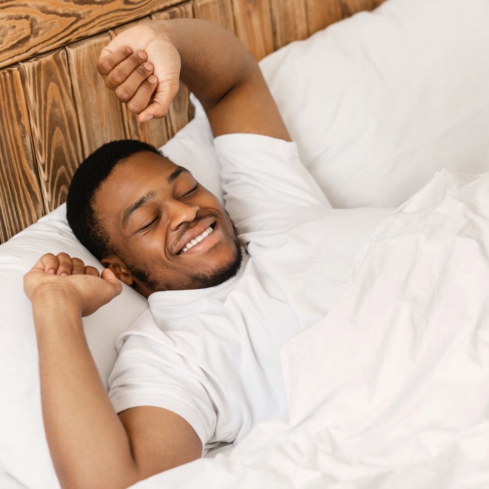 Rested Black Man Waking Up Lying In Bed At Home