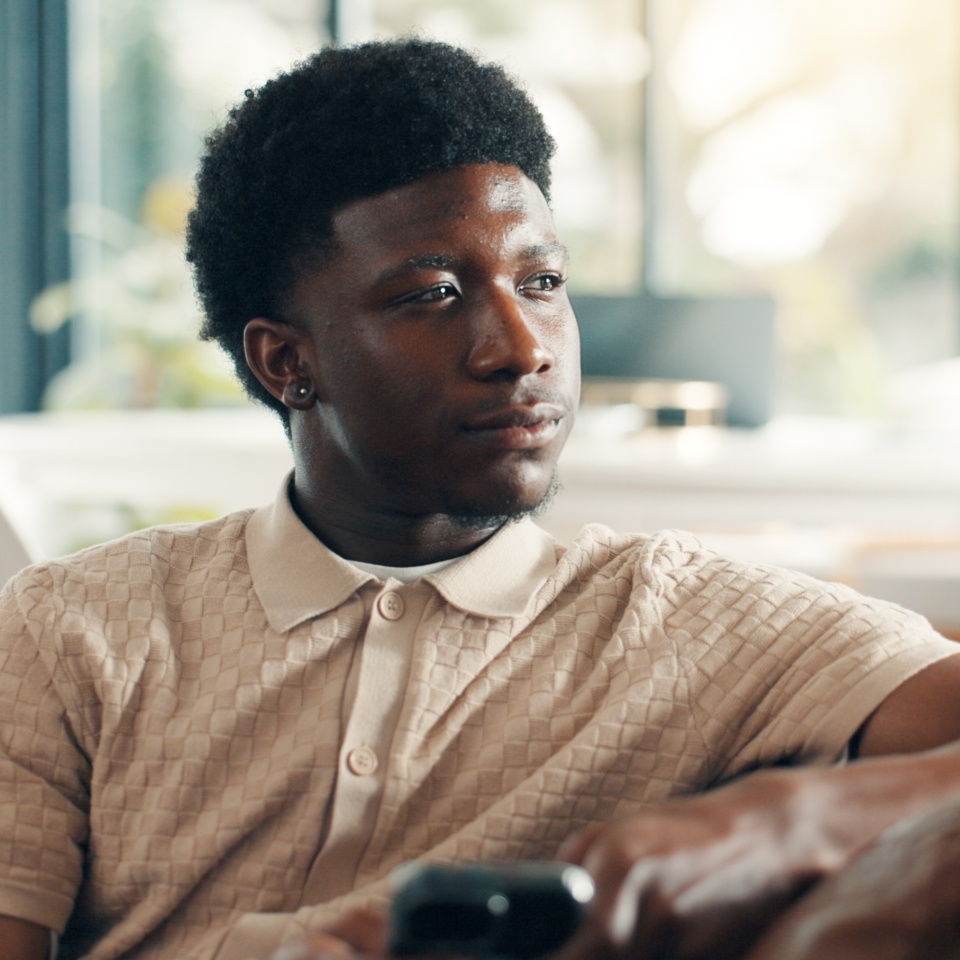 Home, thinking and black man on sofa, smartphone and decision with break, social media and relax. Apartment, cellphone and African person on couch, thoughtful and calm with reflection, app or message